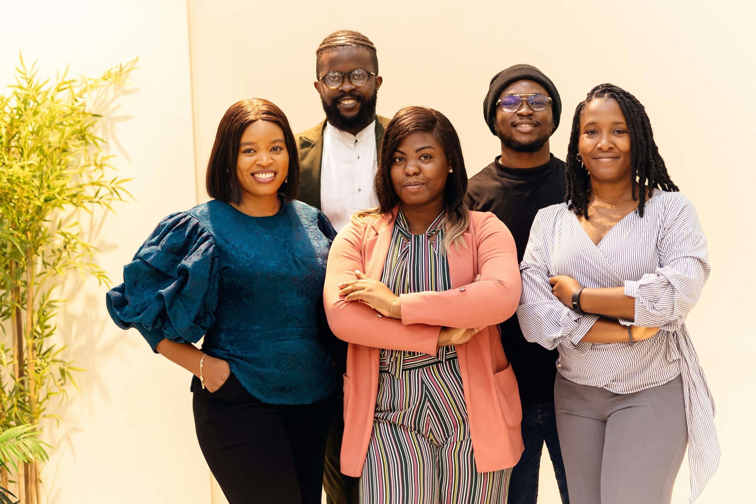 A propos de nous/ Zintyko homes A diverse group of business professionals smiling confidently indoors.
